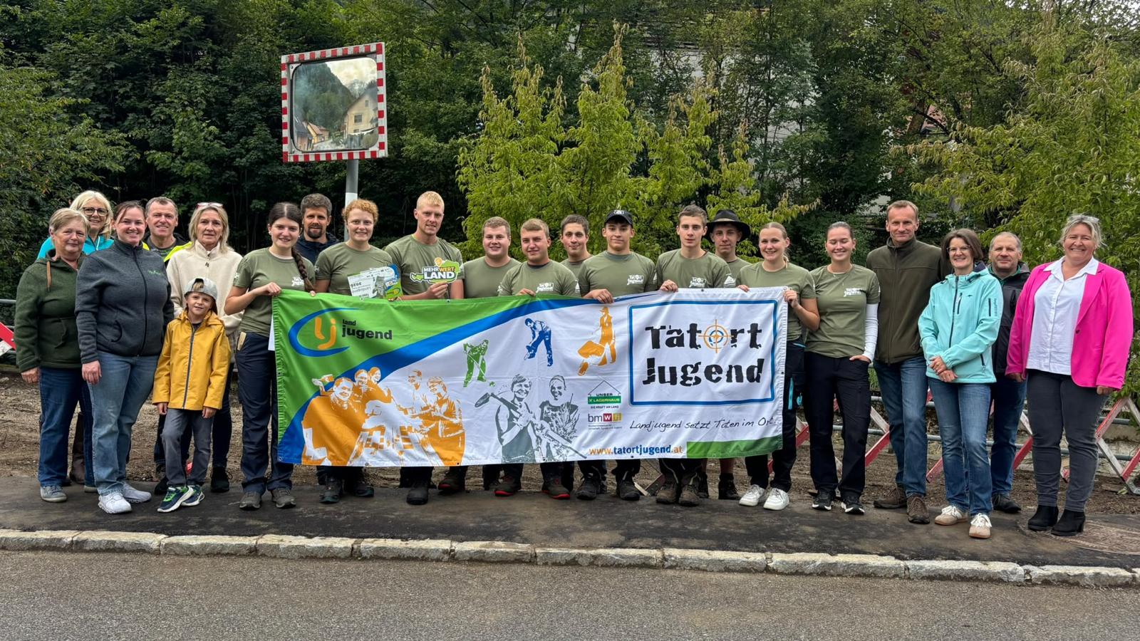 Landjugend-Gruppe mit Banner „Tatort Jugend“ vor Bäumen und Spiegel